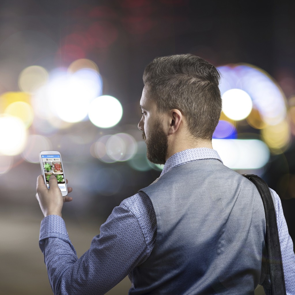 Handsome young hipster with his smartphone outside in the night city